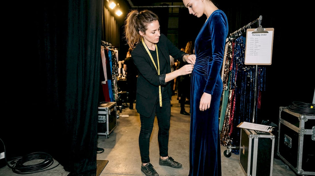 Stylist prepping gown backstage runway